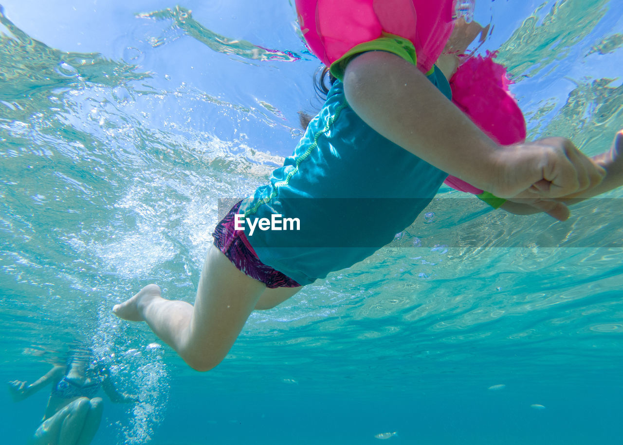 Low section of girl swimming in sea