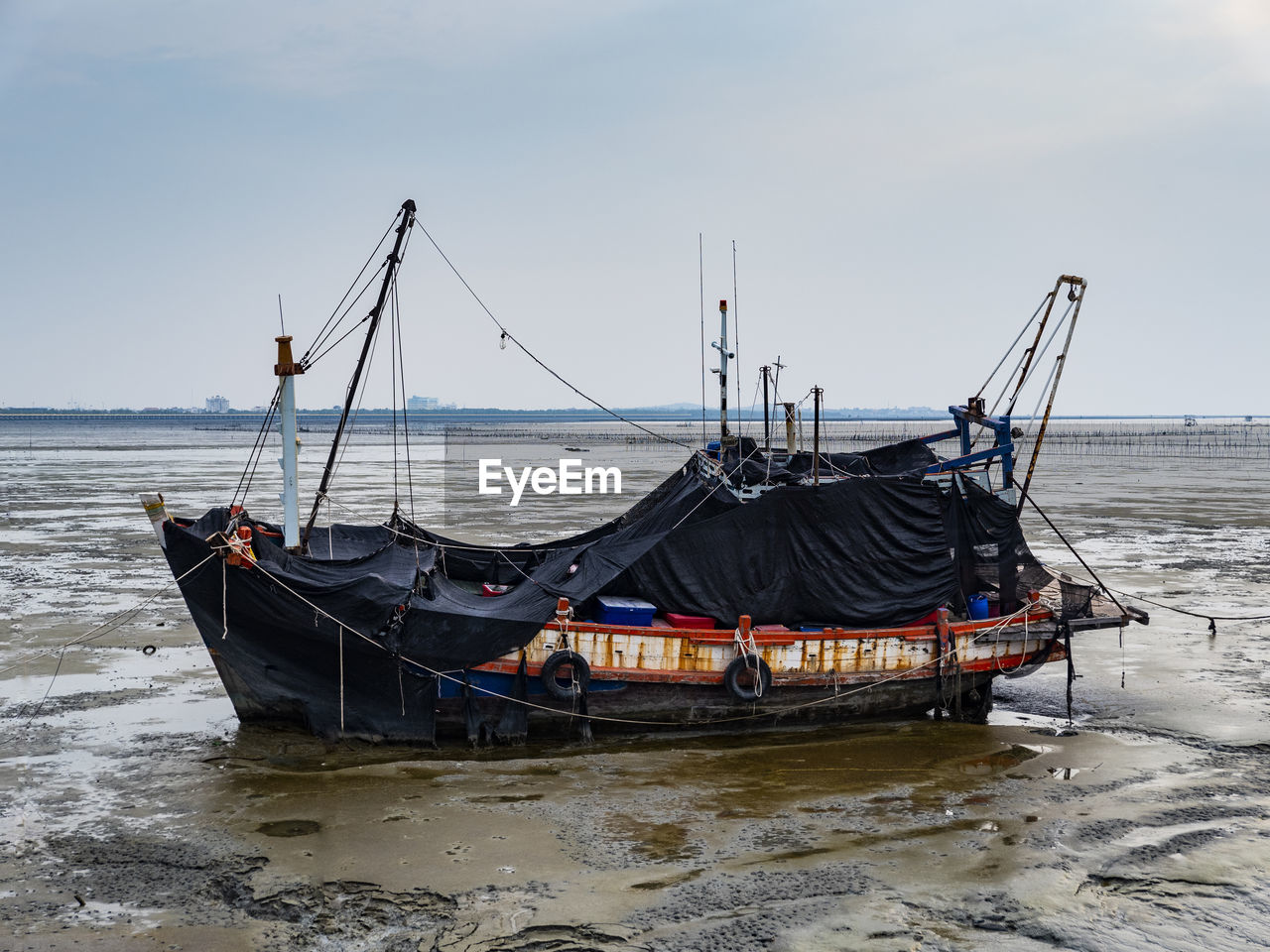 FISHING BOAT ON SHORE AGAINST SKY