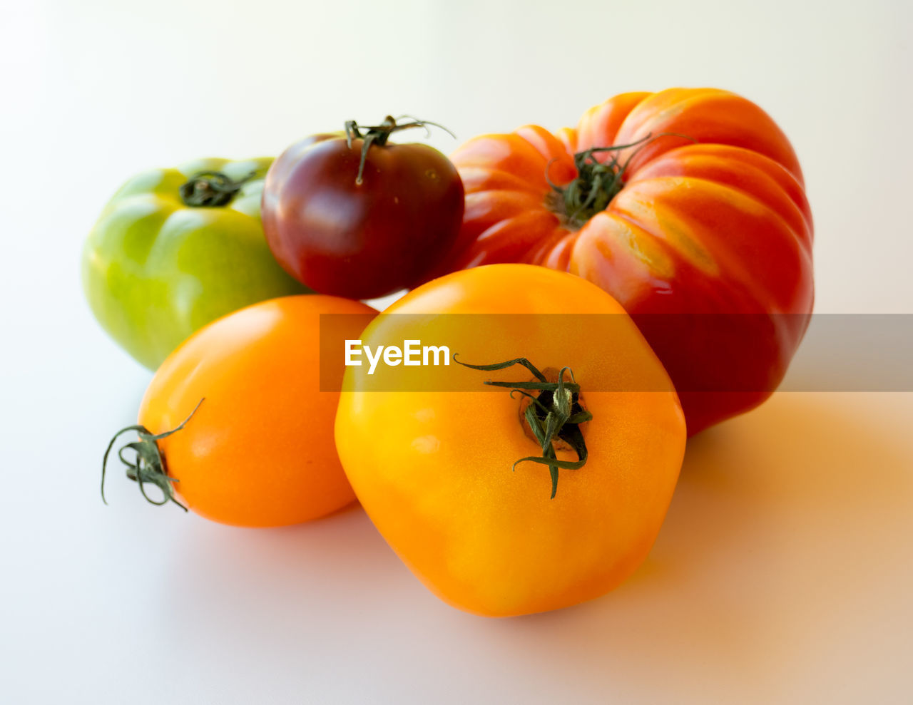 CLOSE-UP OF TOMATOES AGAINST ORANGE BACKGROUND
