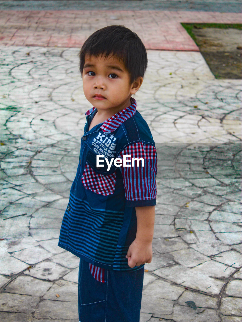 Cute boy standing on footpath