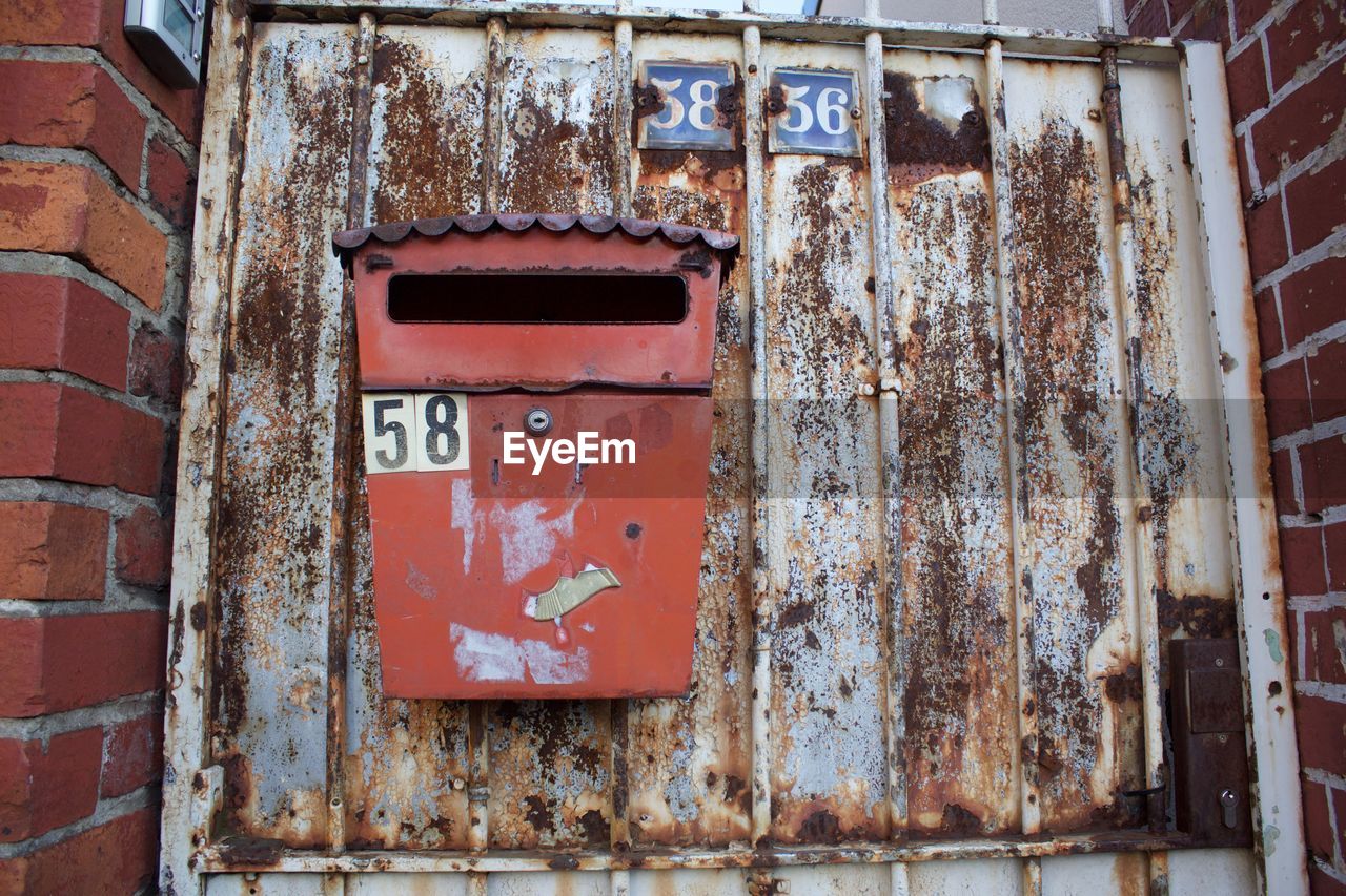 Close-up of old mailbox on rusty door