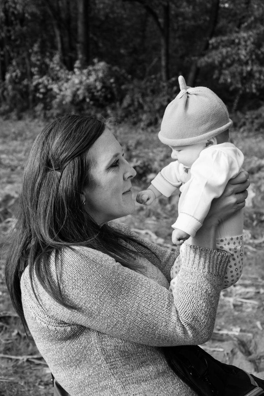 Woman holding baby outdoors