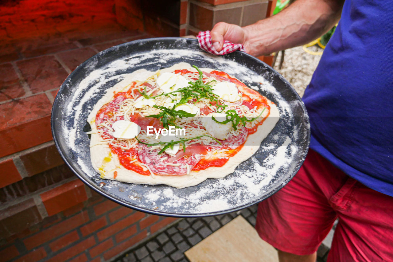 HIGH ANGLE VIEW OF HAND HOLDING FOOD ON TABLE