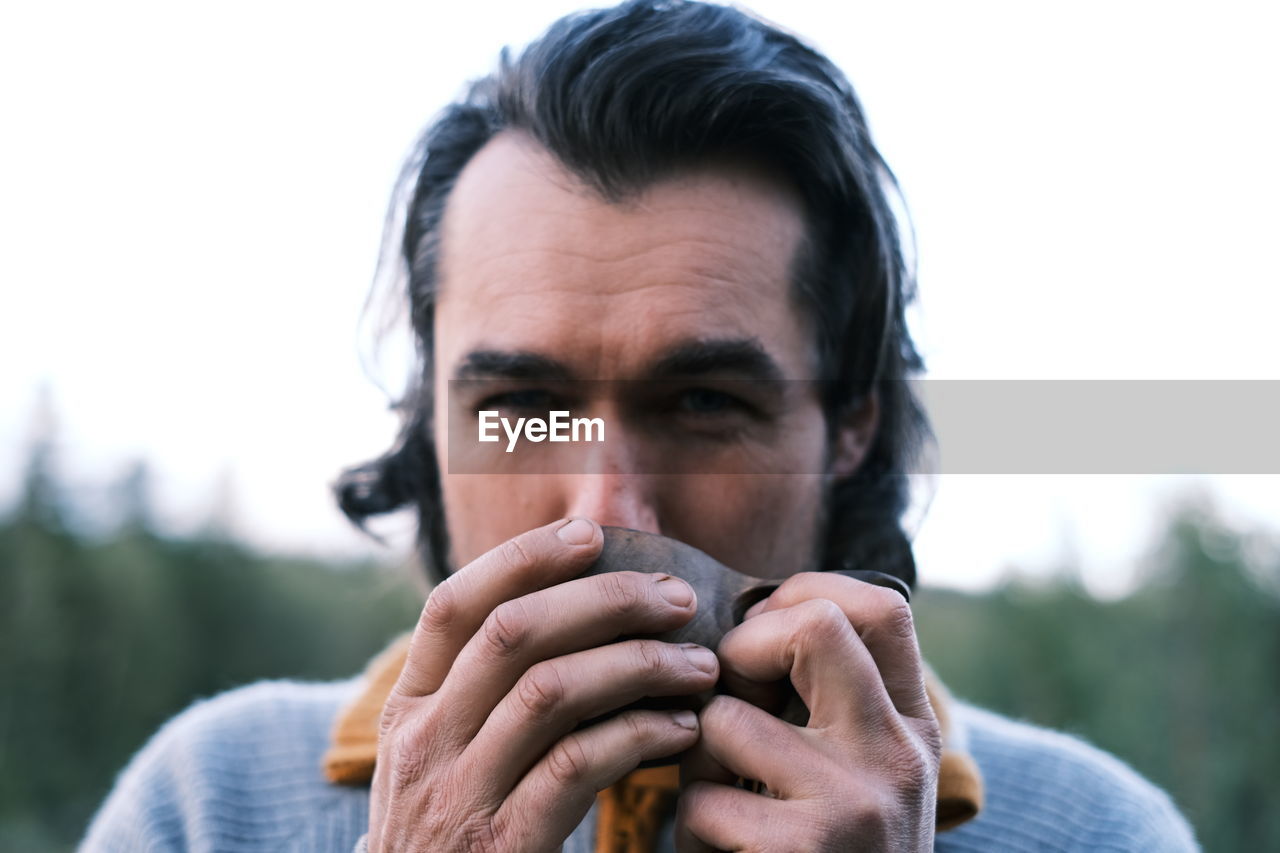 Close-up portrait of man drinking outdoors