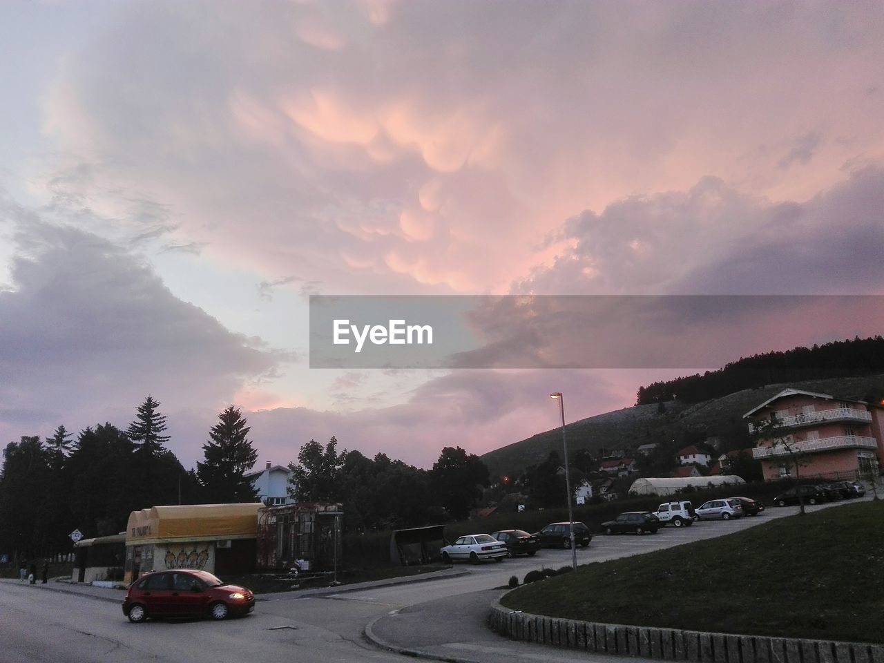 VEHICLES ON ROAD AGAINST SKY AT SUNSET