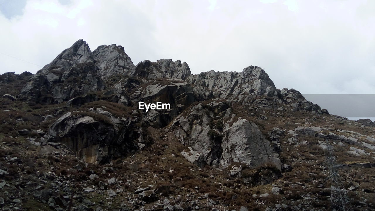 Scenic view of mountains against cloudy sky