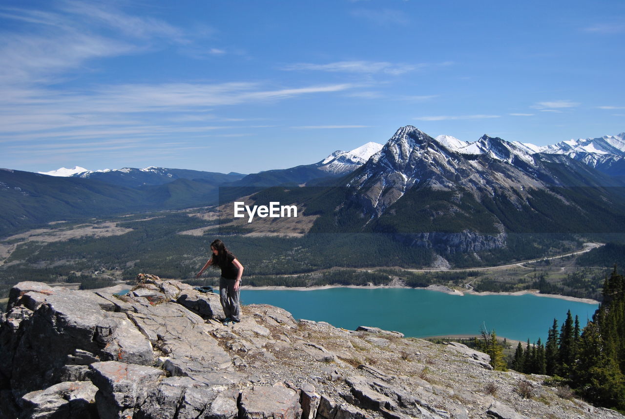 Rear view of a woman standing on mountain against sky