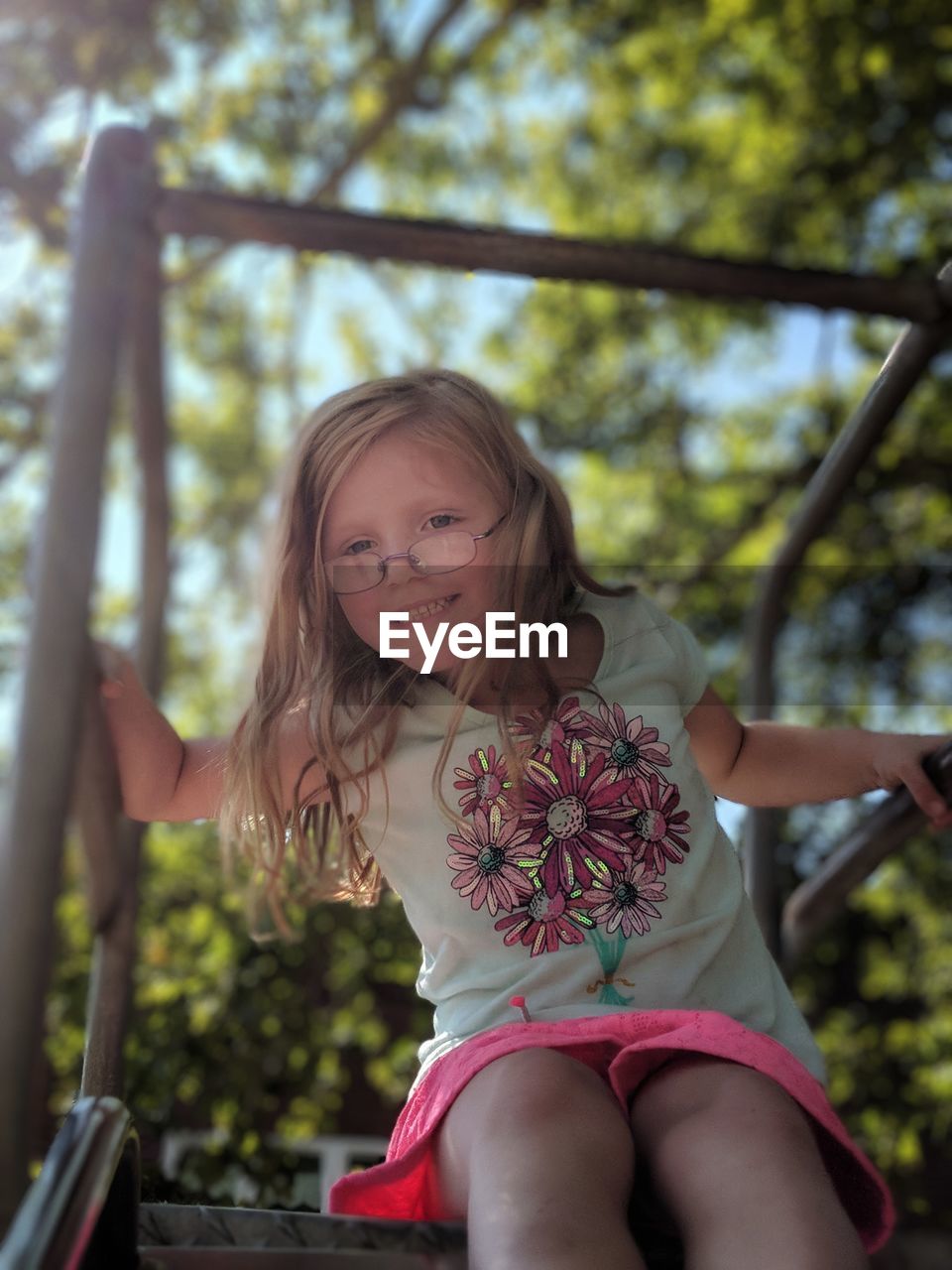 Portrait of smiling girl sitting on slide