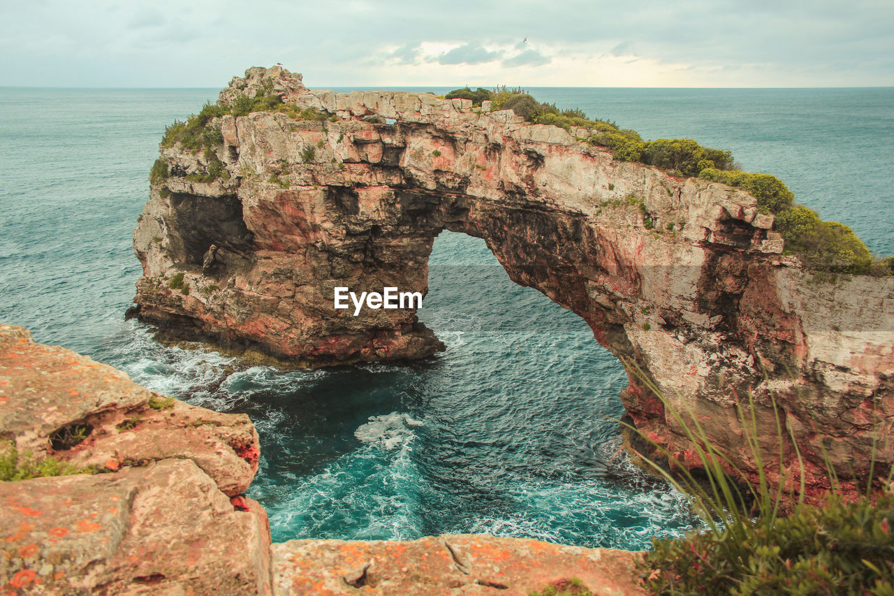 Rock formations in sea against sky