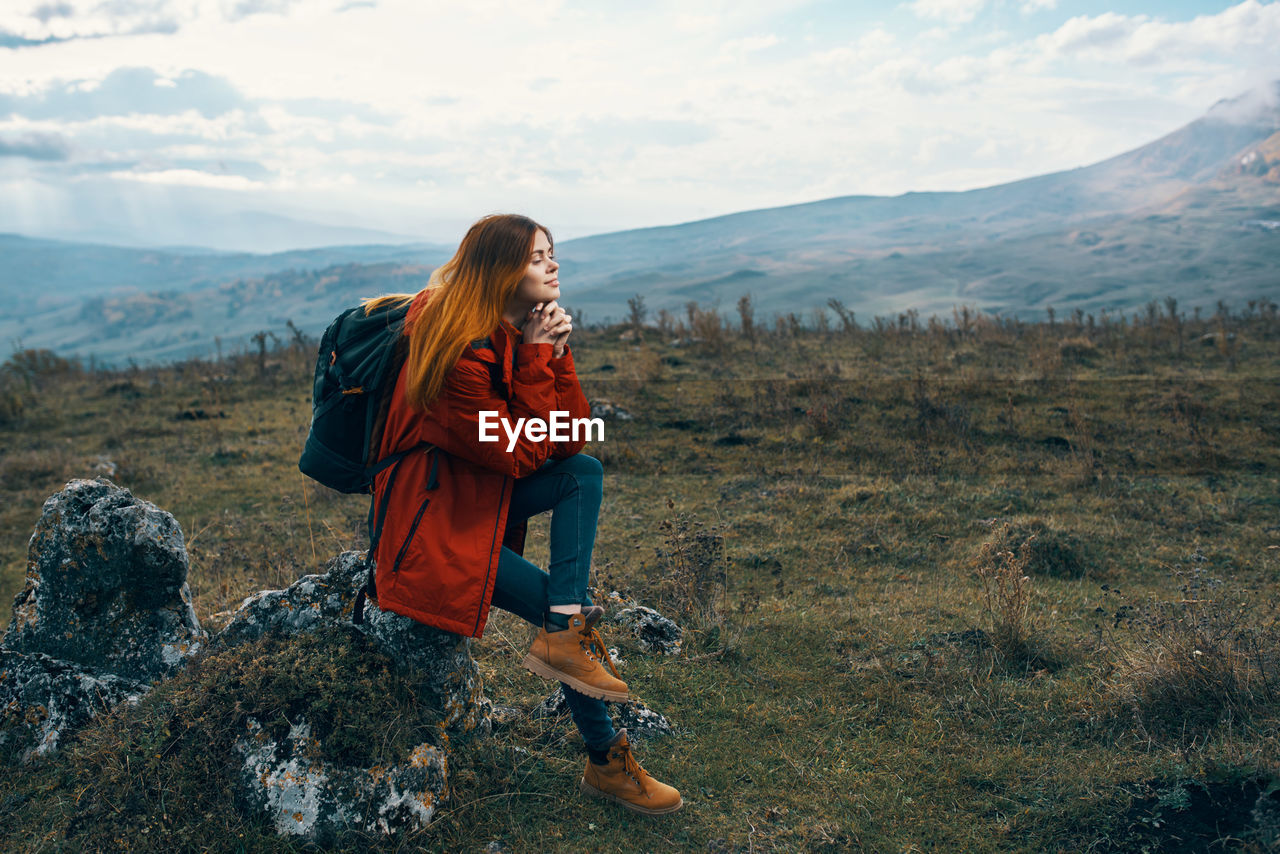 Woman on mountain against sky