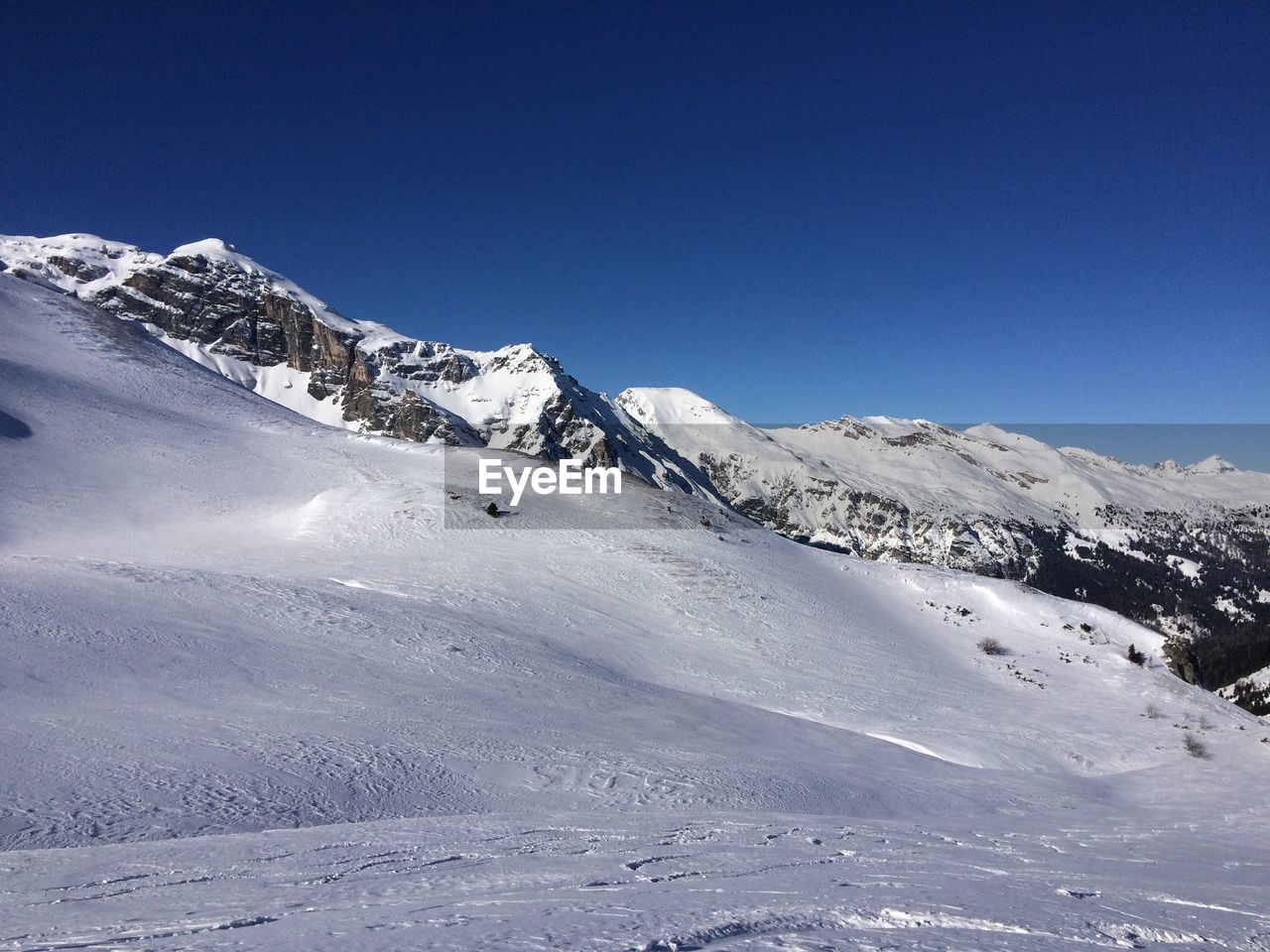 Scenic view of snowcapped mountains against clear blue sky