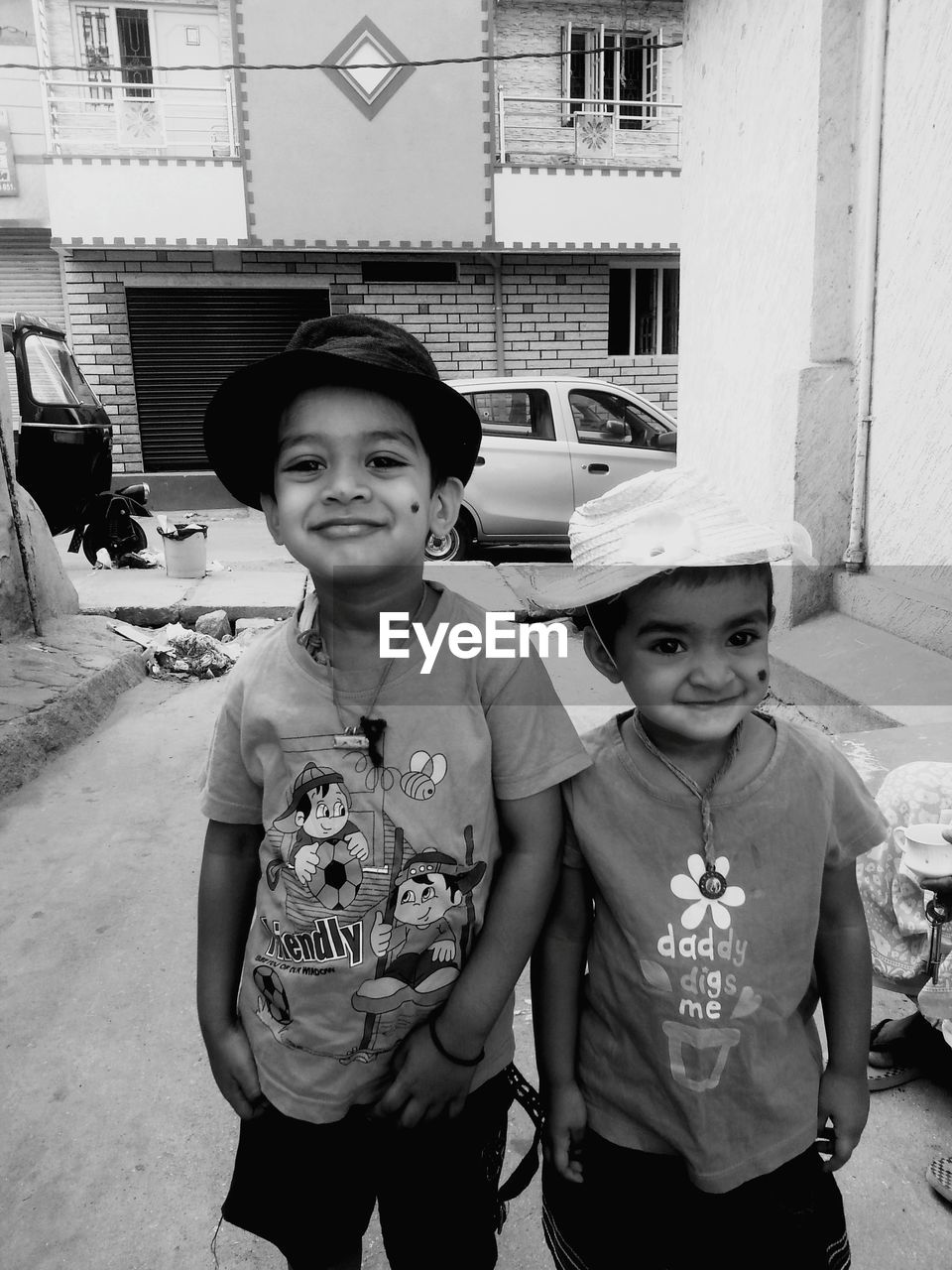 Portrait of smiling brother and sister standing amidst building