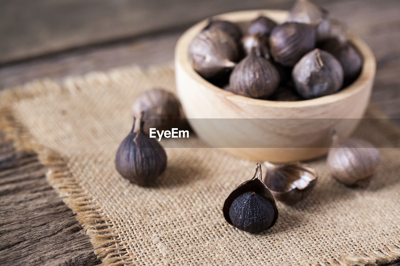 Black garlic on sack cloth and wooden table