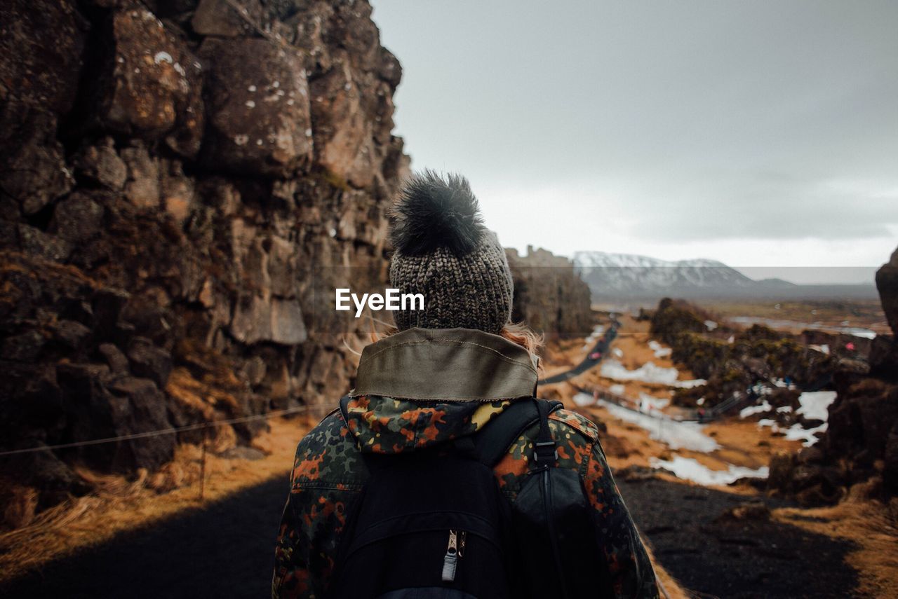 Rear view of woman standing at pingvellir national park during winter