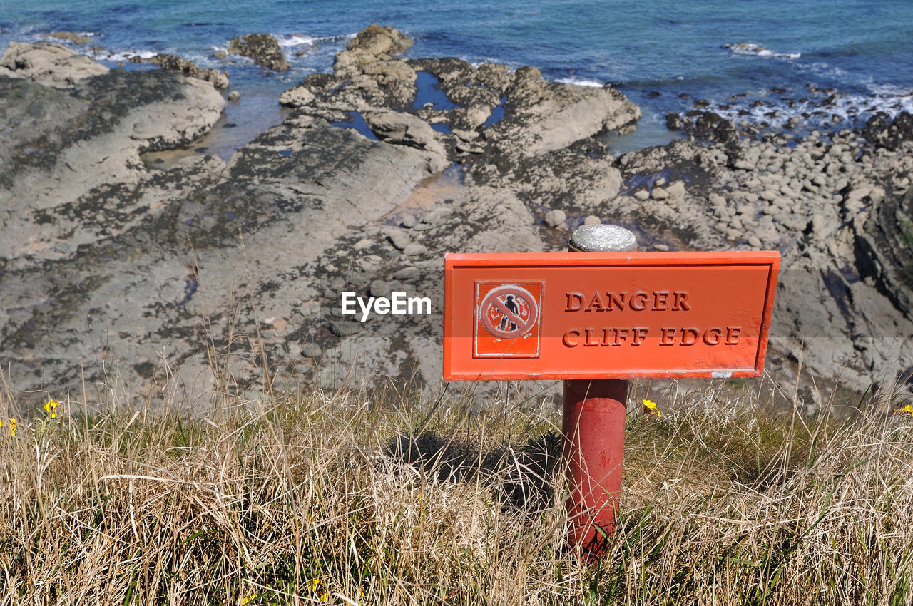 CLOSE-UP OF WARNING SIGN ON LAND