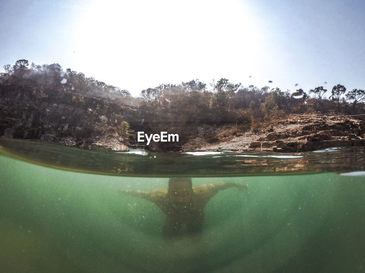 Ma swimming in lake against clear sky