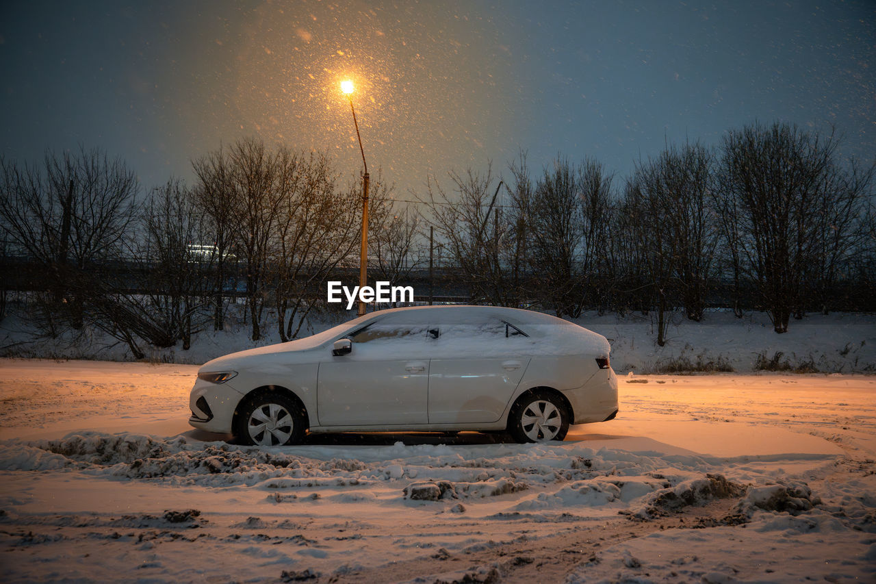 snow, car, motor vehicle, mode of transportation, transportation, winter, cold temperature, nature, sky, tree, vehicle, night, land vehicle, morning, light, road, environment, no people, frozen, scenics - nature, travel, land, plant, dusk, landscape, beauty in nature, street, illuminated, outdoors