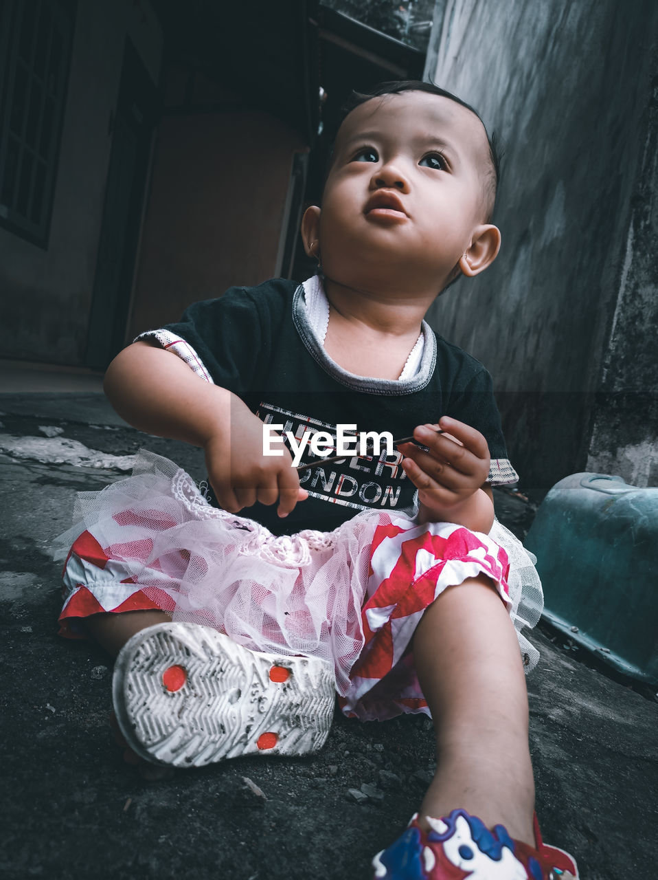 PORTRAIT OF CUTE GIRL SITTING ON FLOOR