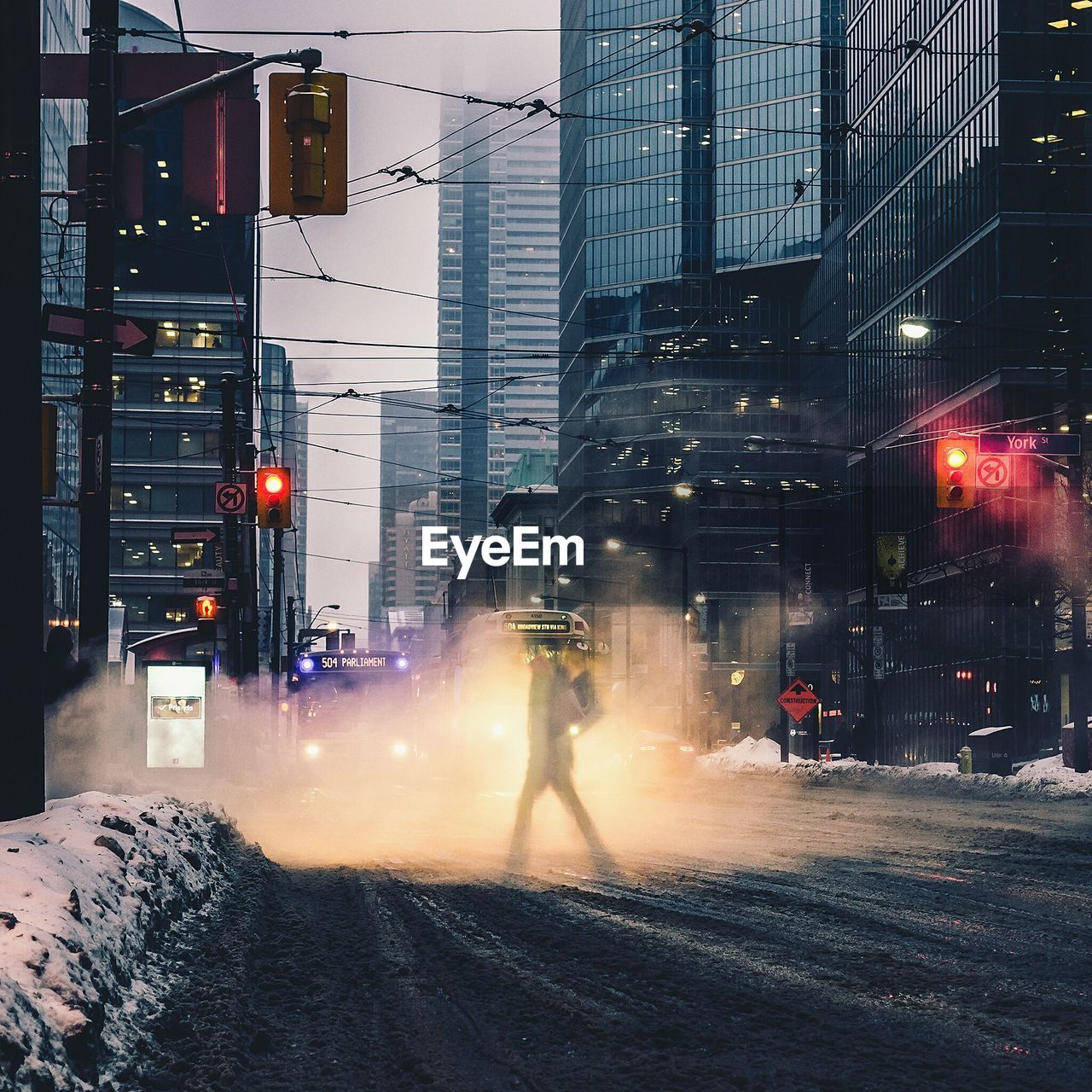 Digital composite image of person crossing street in city during winter