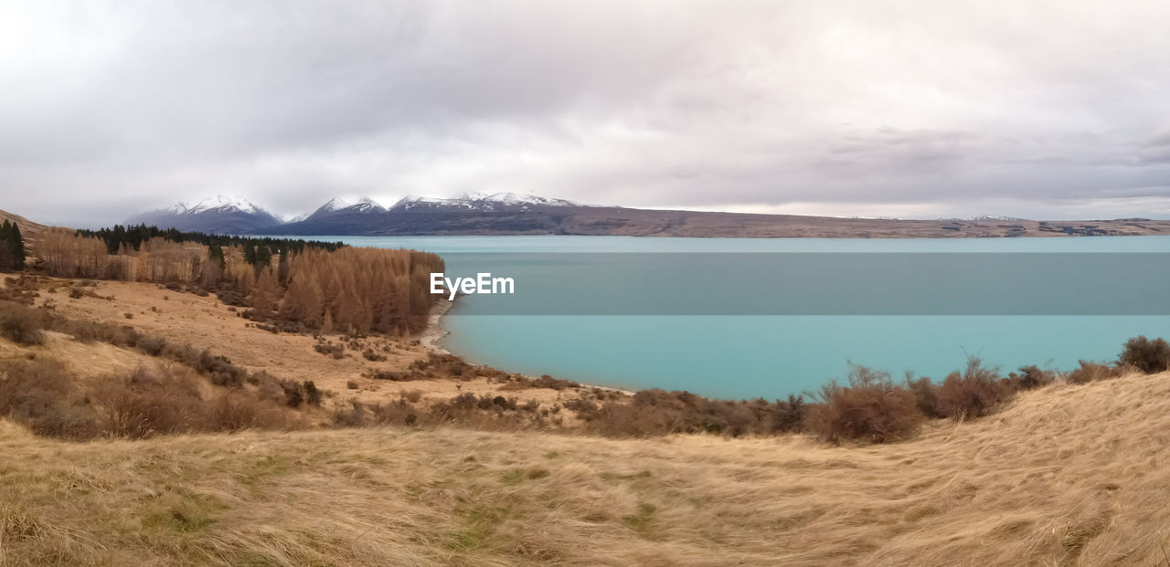 Scenic view of sea and mountains against sky