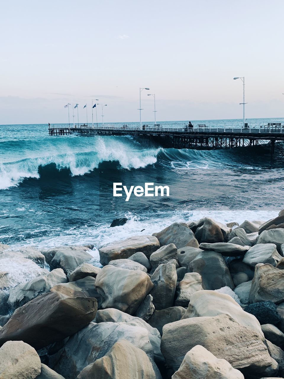 SCENIC VIEW OF ROCKS ON BEACH AGAINST SKY