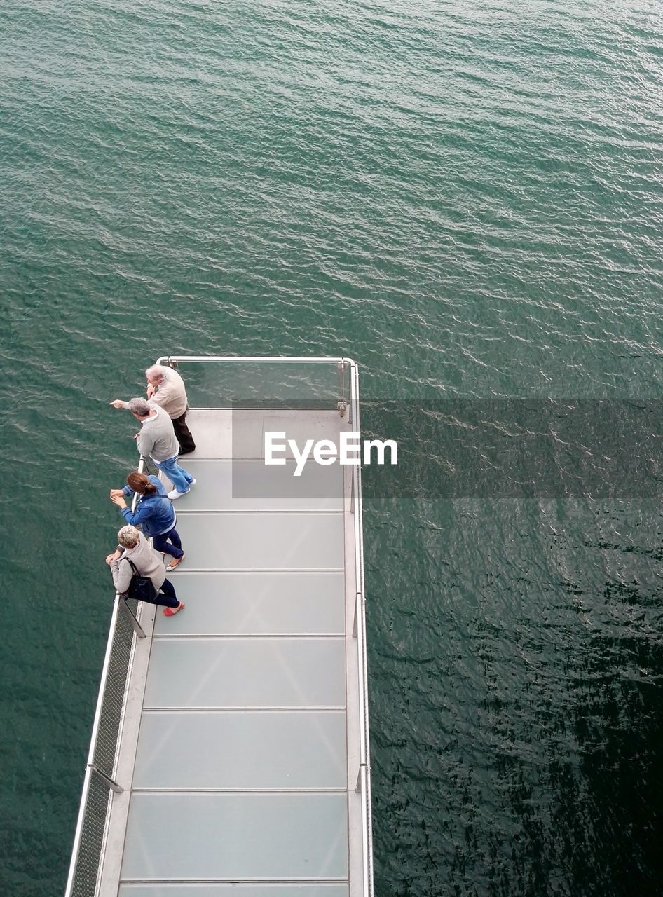High angle view of people standing on pier over sea