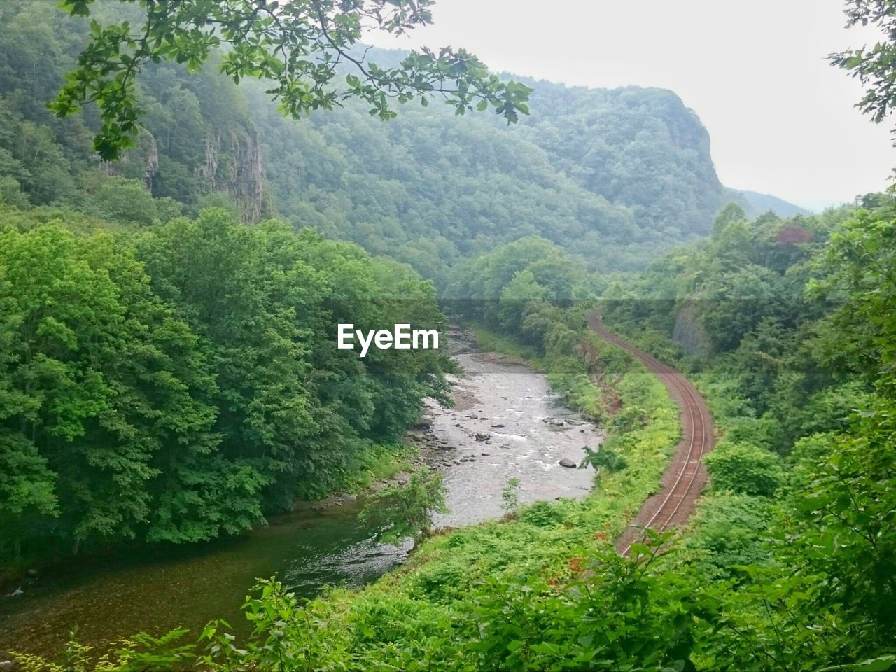 SCENIC VIEW OF WATERFALL ON MOUNTAIN AGAINST SKY