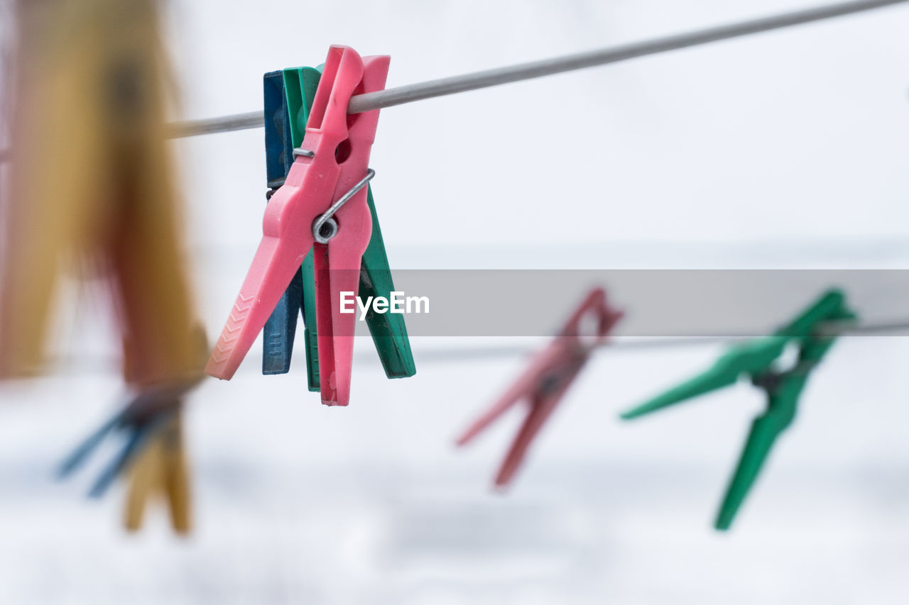 Close-up of colorful clothespins hanging on clothesline