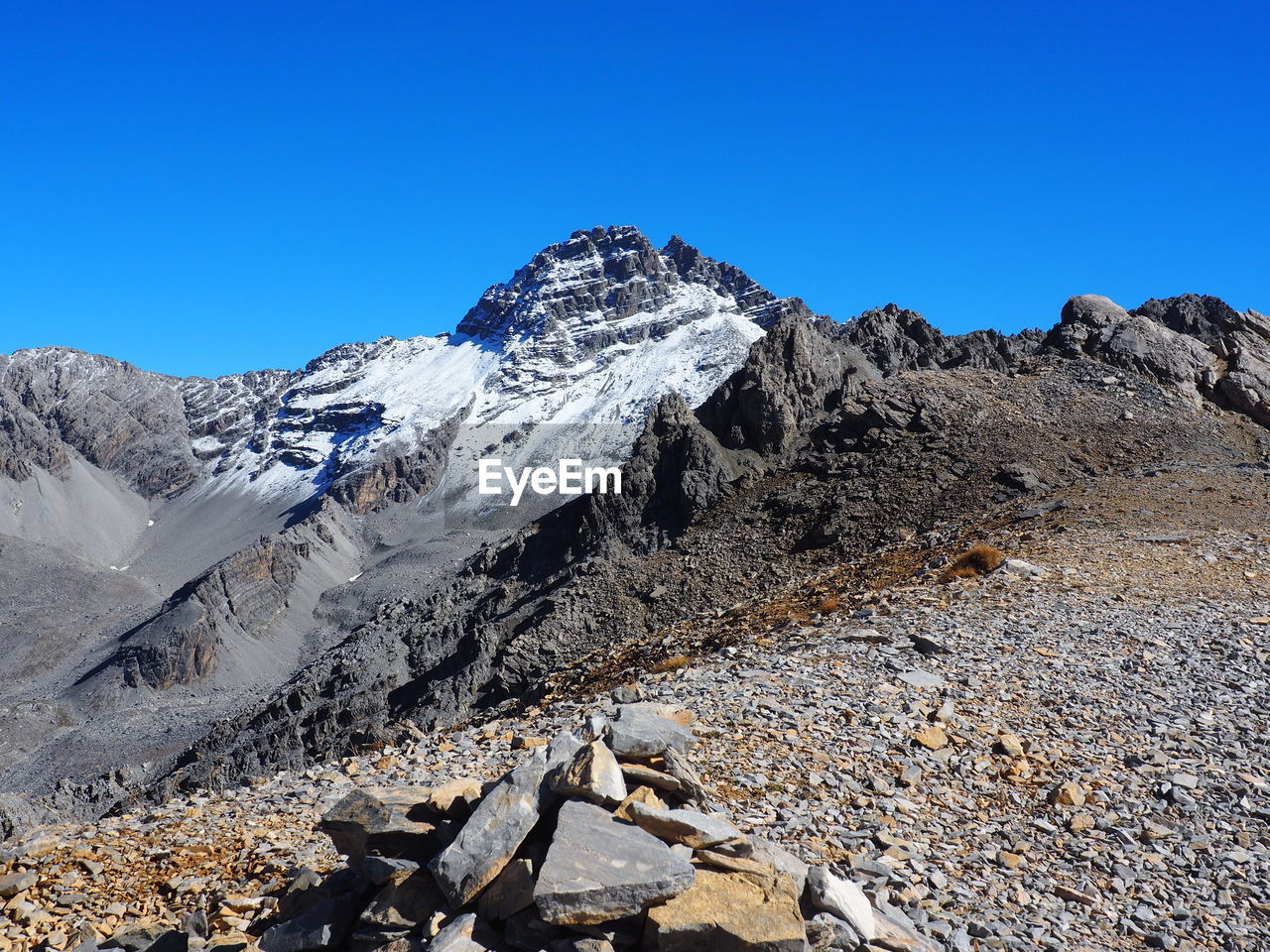 Scenic view of snowcapped mountains against clear blue sky