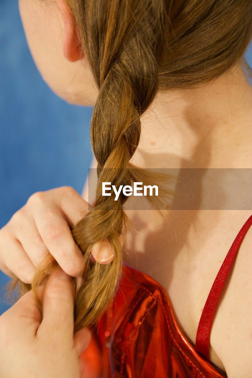 Midsection of woman holding braided hairs outdoors