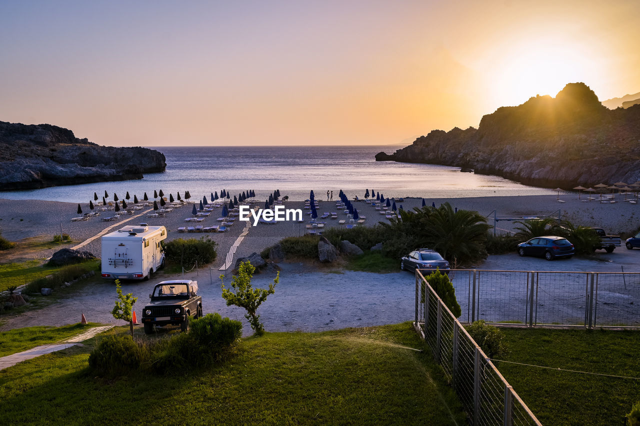 high angle view of people at beach against sky during sunset