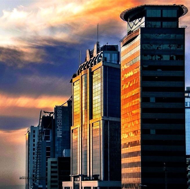 LOW ANGLE VIEW OF MODERN BUILDING AGAINST SKY AT SUNSET