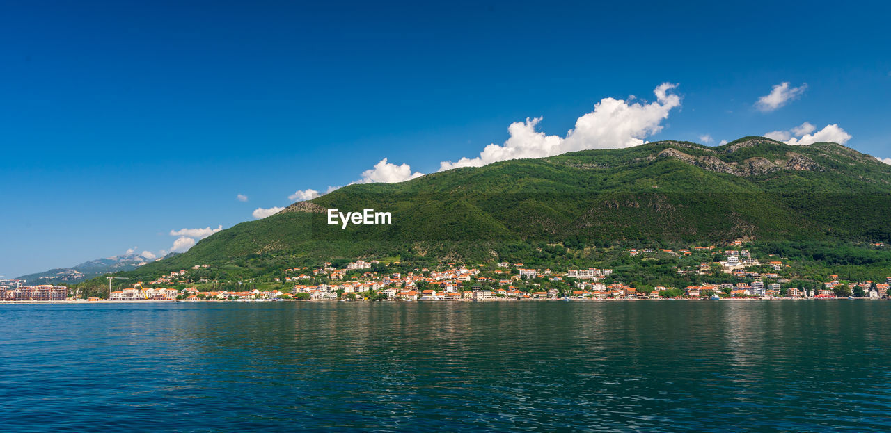 Scenic view of sea and mountains against blue sky