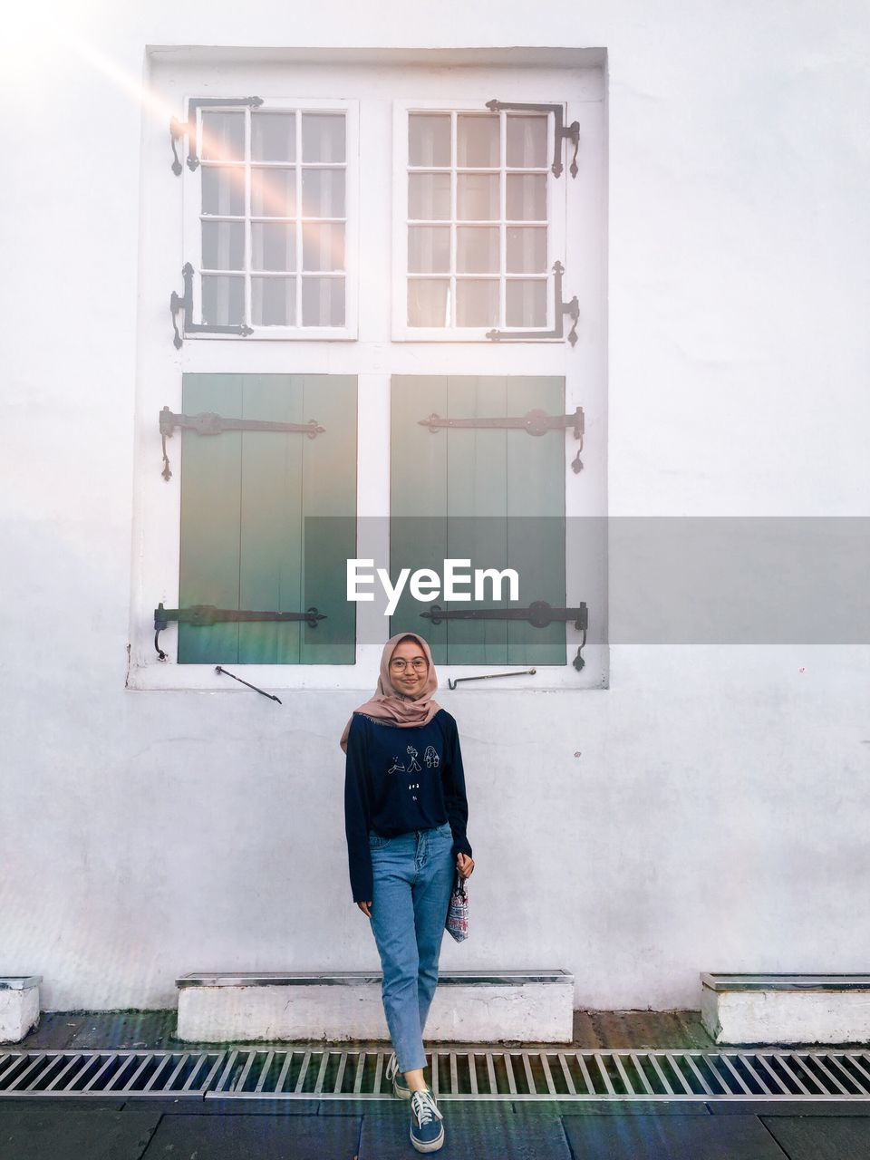 Portrait of woman standing against building