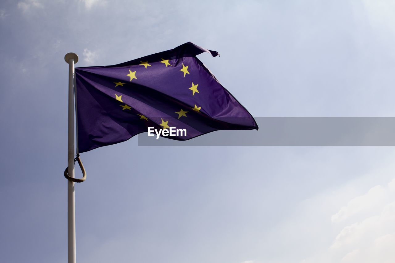 Low angle view of european union flag waving against sky