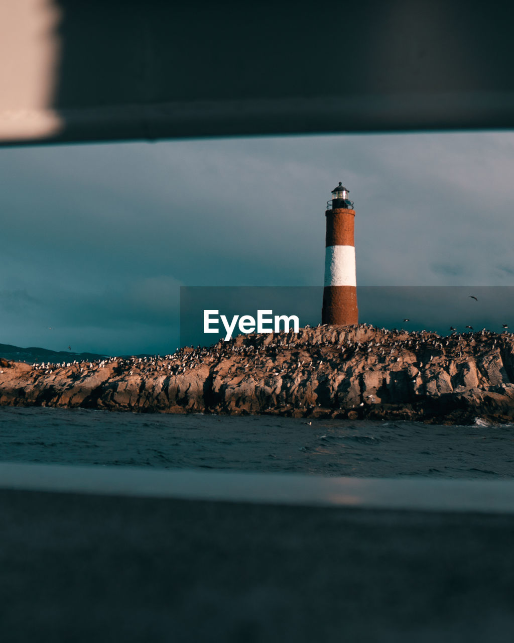 Lighthouse by sea against sky