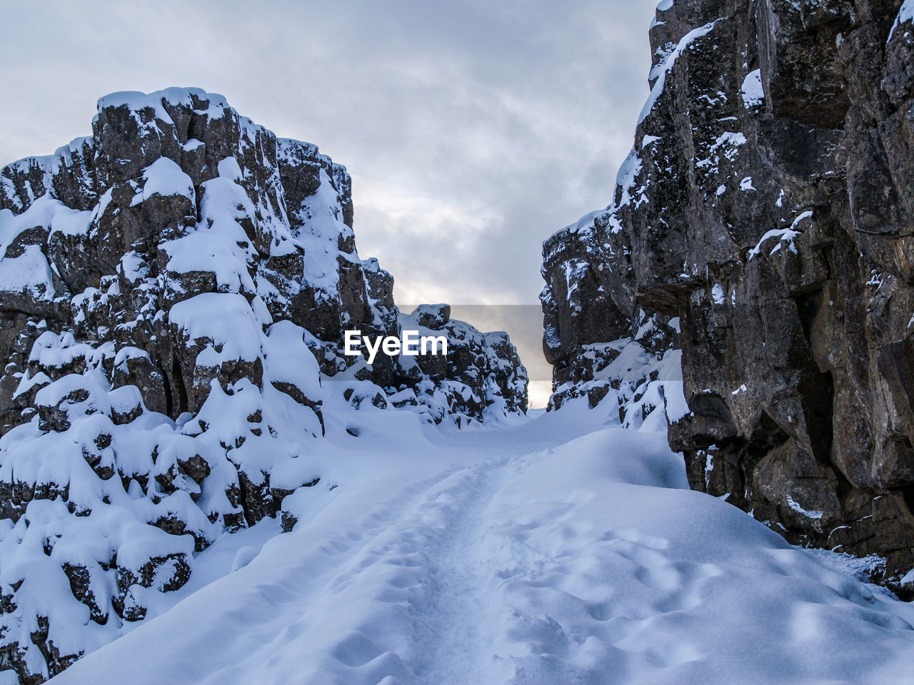 Low angle view of snow covered mountain against sky