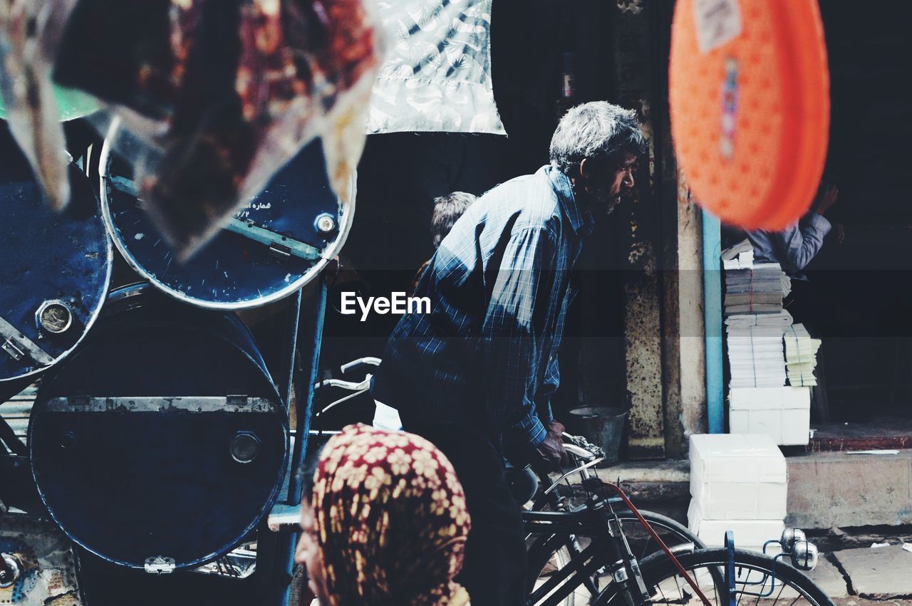 Side view of man riding rickshaw on city street