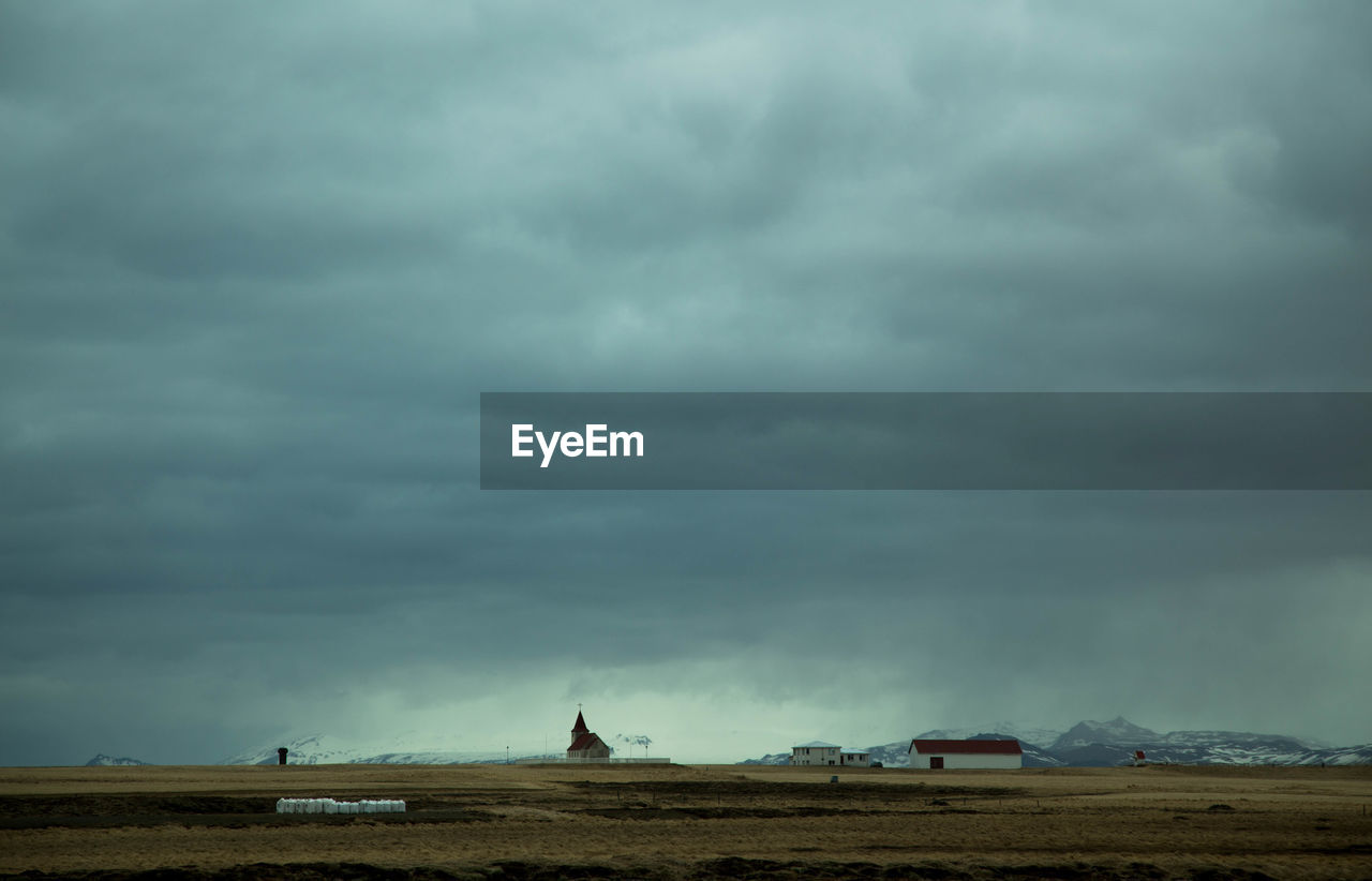 Scenic view of field against storm clouds