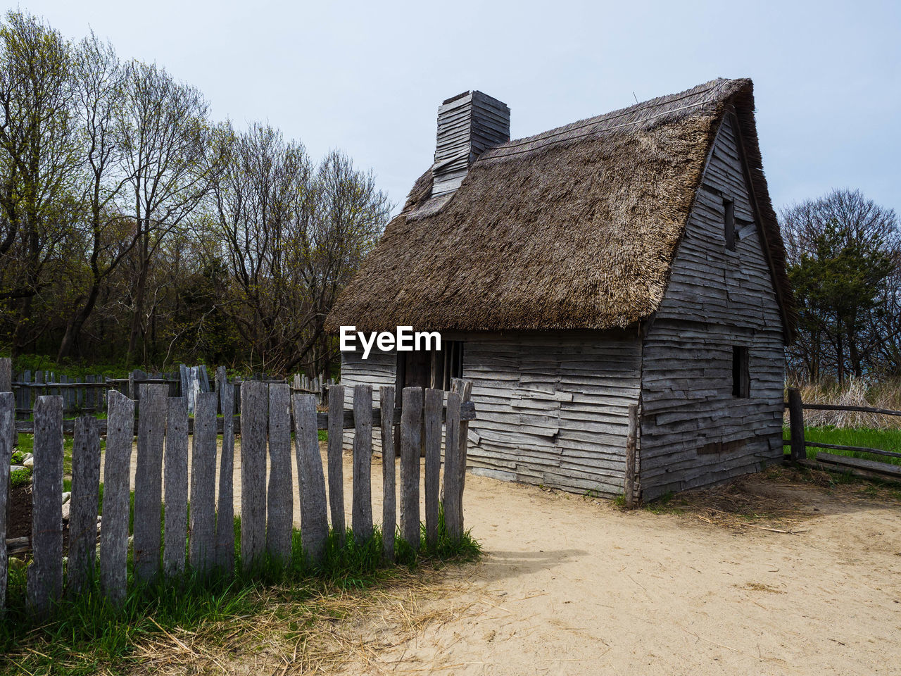 WOODEN FENCE ON FIELD BY BUILDING