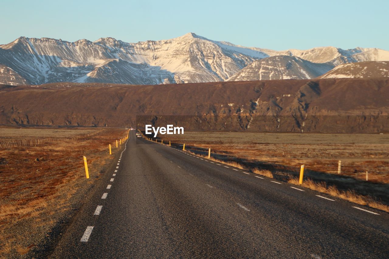 Road by mountain against sky