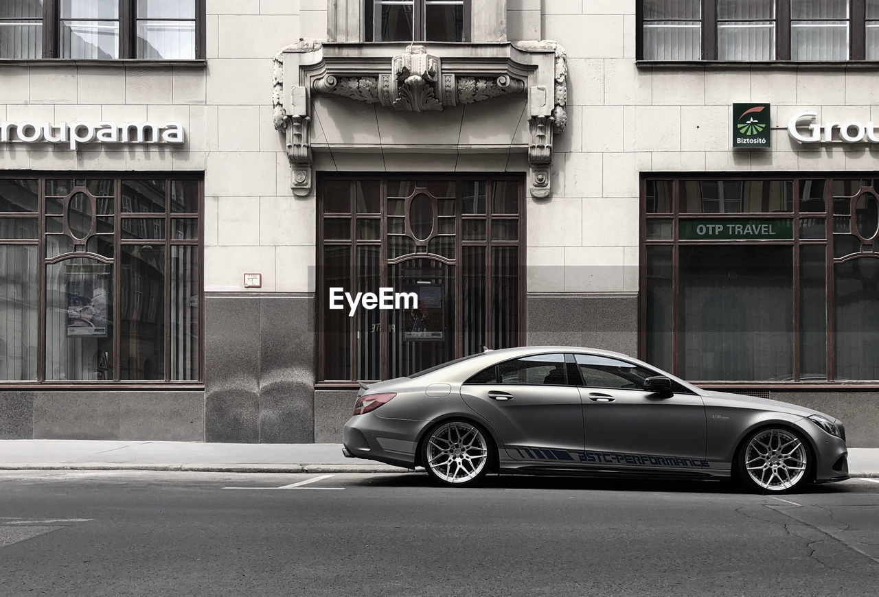 CAR ON STREET AGAINST BUILDINGS