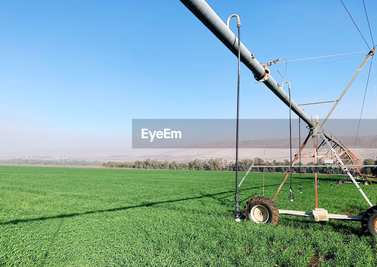 Scenic view of agricultural field against clear sky, with agricultural equipment