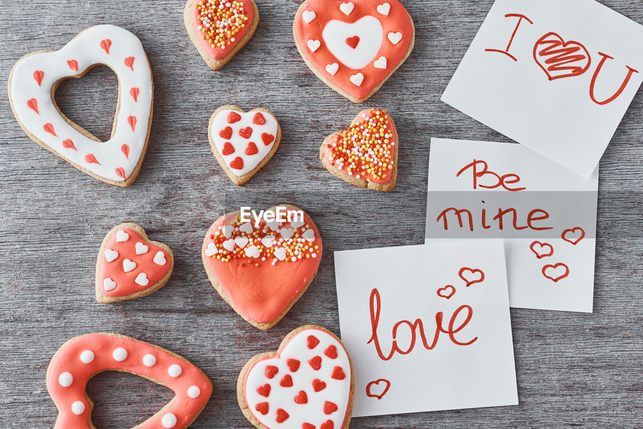 Deocrated heart shape cookies and paper sheets with inscriptions be mine, love and i love