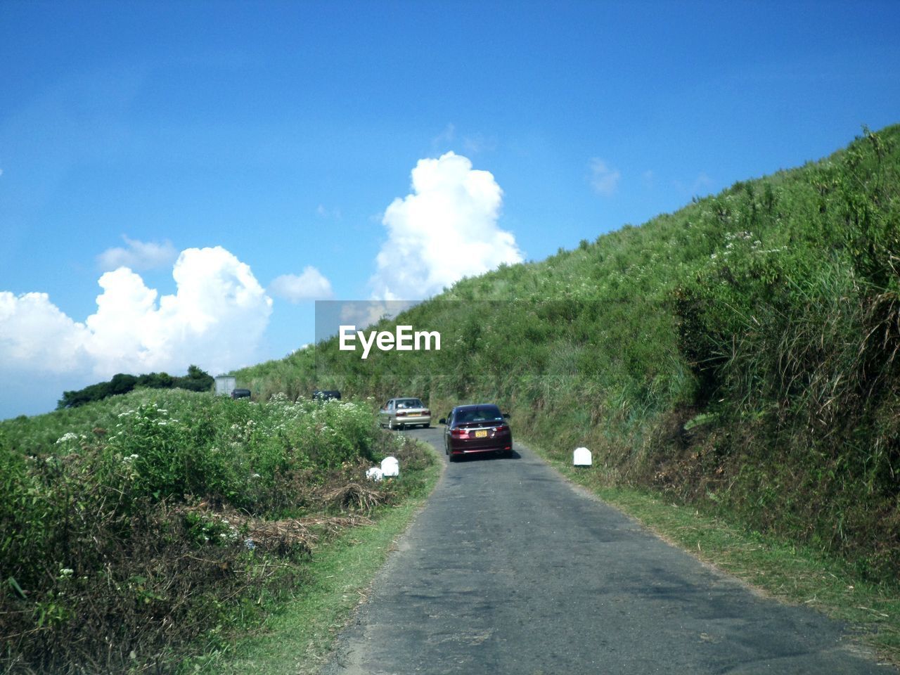 Cars on road by mountain against sky