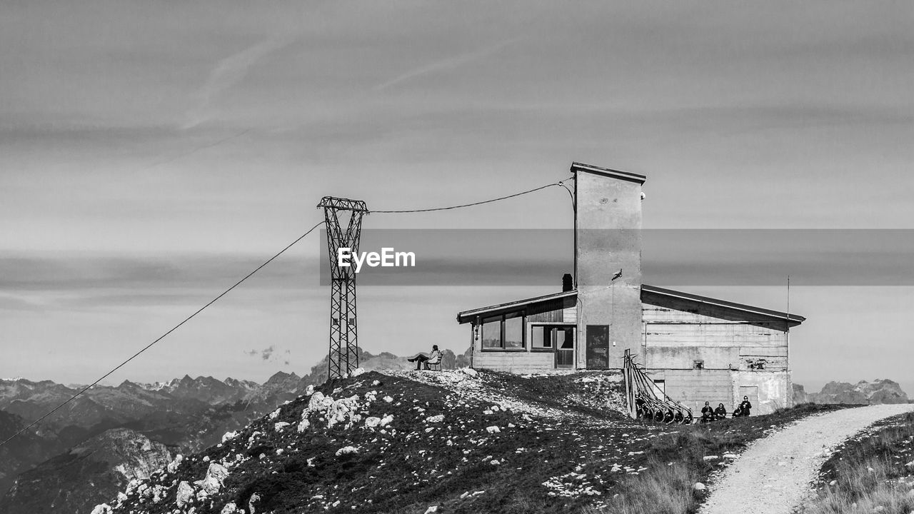 HOUSE BY BUILDING AGAINST SKY