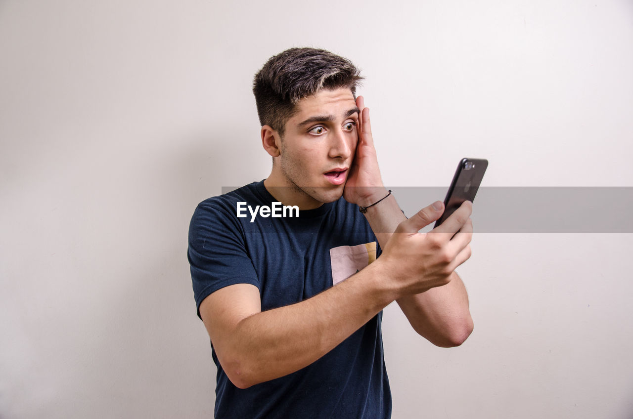 YOUNG MAN USING MOBILE PHONE