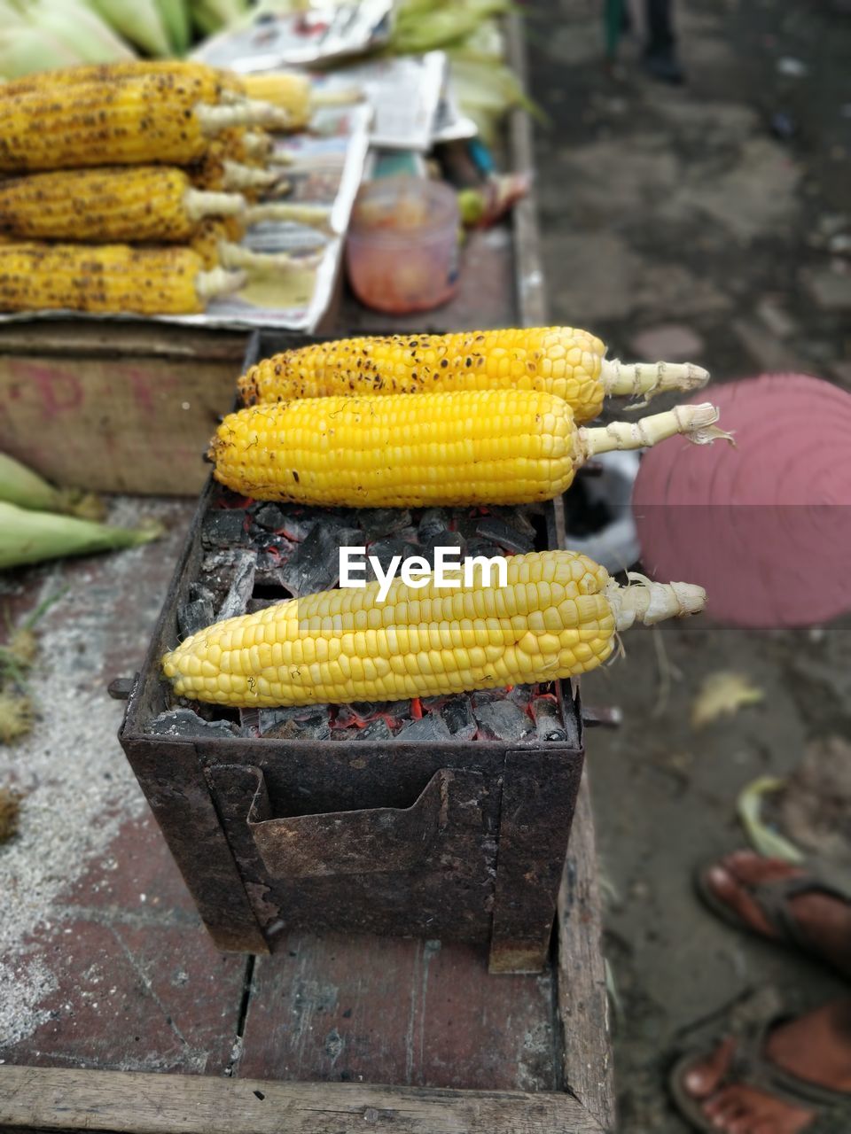 High angle view of yellow corn on bbq for sale at market