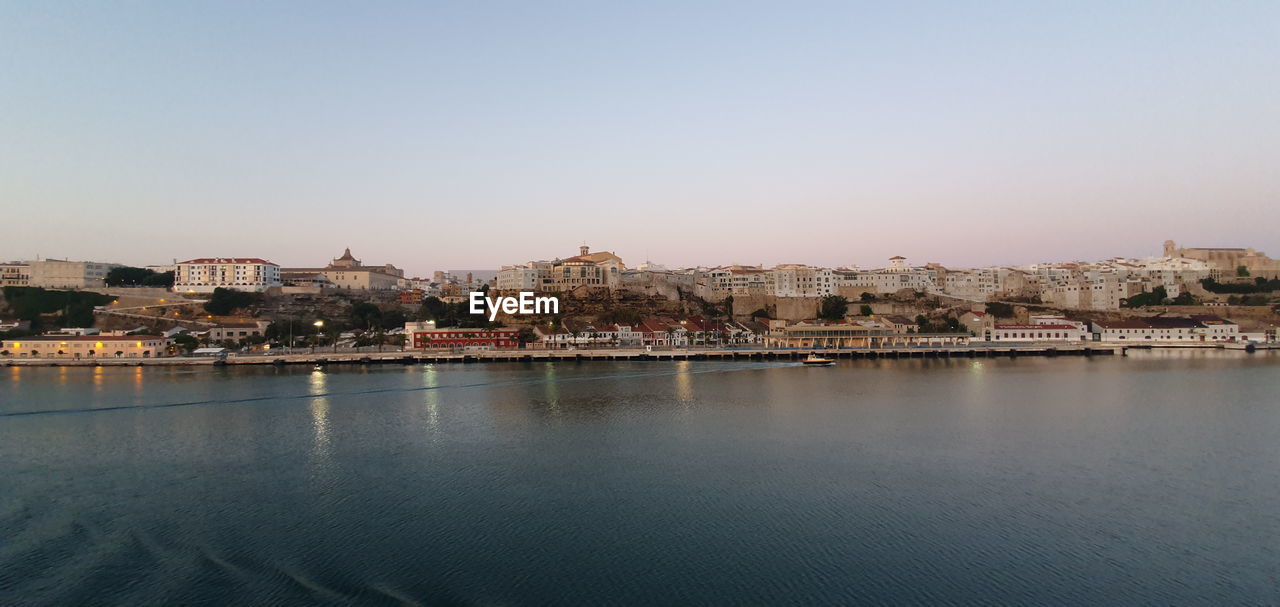 Buildings in city against clear sky and sea