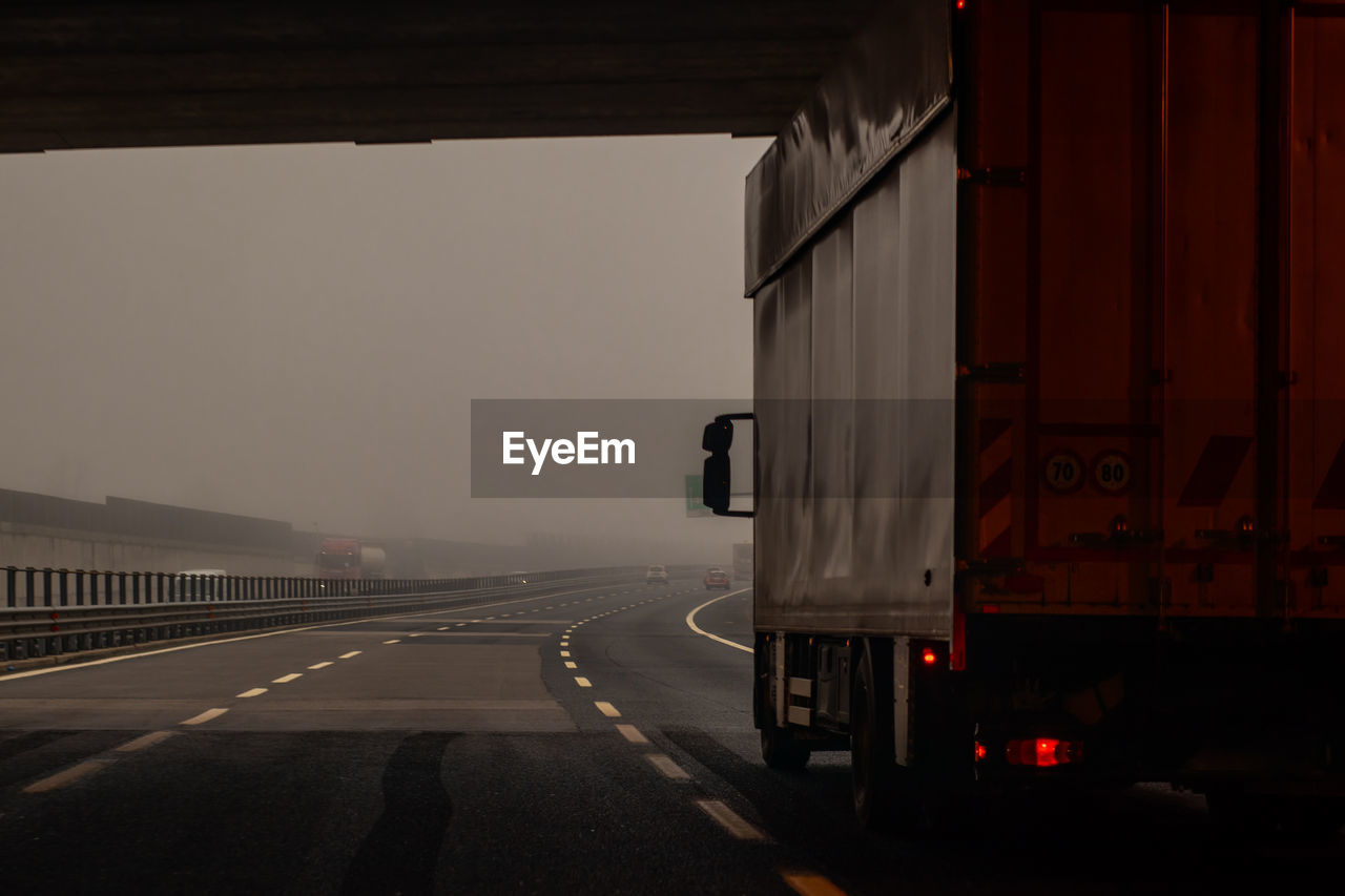 VEHICLES ON ROAD AGAINST THE SKY